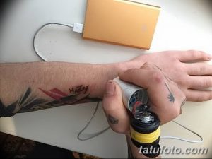 Фото процесса нанесения татуировки с использованием самодельной тату-машинки. Вид руки мастера и руки клиента с наносимым рисунком.
