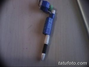 Фото самодельной тату-машинки, собранной из обычной ручки и небольшого моторчика. Детали конструкции видны крупным планом.