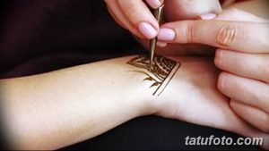 Фото процесса нанесения тату хной на запястье, демонстрирующее работу мастера и детализированный узор. Подходит для тех, кто интересуется техникой мехенди.