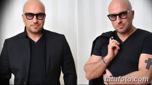 Фотография Дмитрия Нагиева в очках и черном костюме с татуировкой на руке. Видна татуировка в виде креста и надписи.