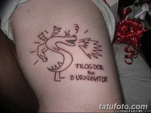 Фото тату на руке: примитивный рисунок красного дракона с надписью "Trog Dor the Burninator". Непрофессиональная работа, низкое качество, юмористический стиль.