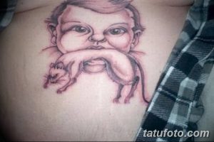 Фото неудачной татуировки младенца, держащего мышь, на груди. Рисунок выполнен неаккуратно, с искаженными пропорциями и странным выражением лица.