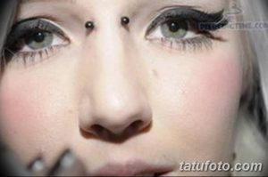 Фотография девушки с пирсингом брови и большими глазами, демонстрирующая нежный и романтичный образ. Подходит для поиска идей для пирсинга.