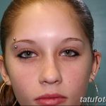 Фотография девушки с пирсингом брови и ушей, с длинными волосами и легким макияжем. Идеальный пример для вдохновения перед пирсингом.