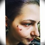 Фотография девушки с двойным пирсингом брови. В брови вставлены два серебристых шарика, которые подчеркивают ее выразительные глаза.
