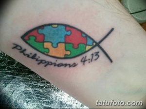 Фото тату: символ рыбы, составленный из элементов пазла, с надписью 'Philippians 4:13'. Яркий рисунок татуировки с религиозным подтекстом.