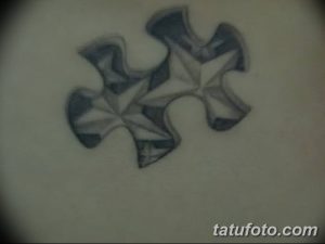 Фото тату двух соединенных кусочков пазла на коже. Черно-белый рисунок татуировки с реалистичной детализацией.