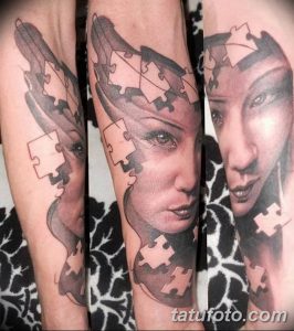 Фото тату женского лица, собранного из кусочков пазла, на руке. Черно-белый рисунок татуировки с реалистичной детализацией и элементами абстракции.