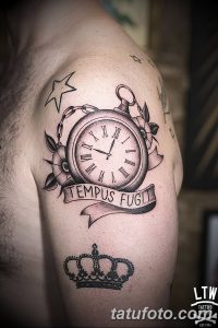 Фото тату на плече: карманные часы с надписью 'Tempus Fugit', короной и звездой. Черно-серый рисунок татуировки в стиле олдскул.
