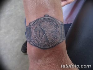Фото тату на запястье: реалистичное изображение часов с металлическим браслетом, выполненное в черно-серых тонах. Простой и стильный рисунок татуировки.