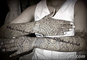 Фото тату хной на обеих руках, демонстрирующее сложный и детализированный узор. Традиционный восточный стиль, коричневые оттенки, узоры на ладонях и тыльной стороне.