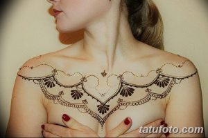 Фото тату мехенди на груди и плечах, выполненное в традиционном стиле с использованием коричневых оттенков и сложных узоров.
