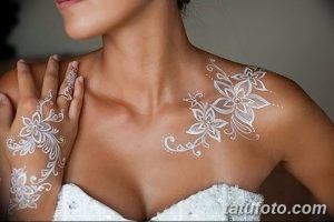 Фото тату белой хной на руке и плече: изящный цветочный узор с тонкими линиями и детальной проработкой лепестков.
