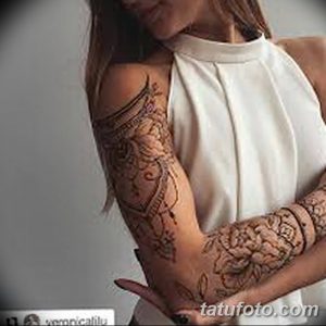 Фото тату мехенди, покрывающее предплечье девушки. Сложные узоры в коричневых тонах, имитирующие рукав.