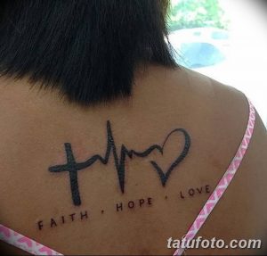 Фото тату: крест, сердце в форме кардиограммы и надпись 'Faith, Hope, Love' на спине. Религиозная татуировка с глубоким смыслом.