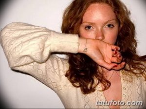Фото тату маленькой буквы 'B' на запястье. Изображение выполнено в черном цвете, в минималистичном стиле.