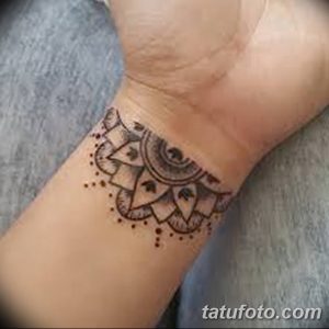 Фото тату на запястье: небольшая мандала, выполненная в технике blackwork с тонкими линиями и точками.