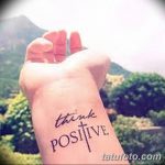 Фото тату надписи 'think positive' на запястье. Рукописный шрифт, выполненный черными чернилами. Идеально для тех, кто верит в силу позитивного мышления.