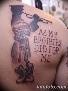 Фото татуировки на плече: солдат с оружием и надписью "As My Brothers Did For Me". Патриотический рисунок в черно-серых тонах.
