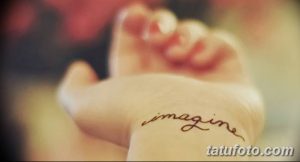 Фото тату с надписью 'imagine' на руке. Тонкая, изящная надпись, выполненная черными чернилами. Минималистичный стиль.