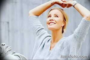 Фото девушки с татуировкой на запястье, смотрящей в небо. Модный и расслабленный образ.