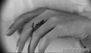 Простая татуировка надписью 'Love' на пальце руки. Черно-белый рисунок, выполненный в минималистичном стиле.