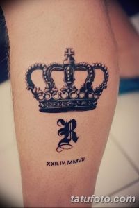 Фото тату на предплечье: черная корона с инициалами и римскими цифрами. Классический дизайн для мужчин, символизирующий власть и статус.