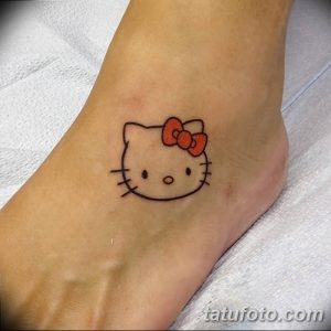 Фото тату: маленькая, простая татуировка Hello Kitty с красным бантиком на лодыжке. Милый и игривый дизайн.