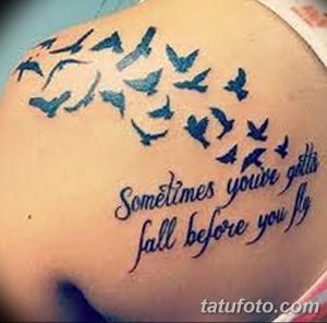 Фото тату: татуировка с изображением стаи голубей и надписью "Sometimes you've gotta fall before you fly" на плече. Сине-голубая палитра, мотивационный смысл.