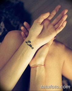 Фото тату надписи 'Love' на запястье. Простой, элегантный рисунок черным цветом, выполненный каллиграфическим шрифтом. Идеально для любителей минимализма.