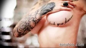 Фото тату на груди: черная надпись 'fuck you forever' каллиграфическим шрифтом. Татуировка выполнена на женской груди.