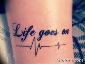 Фото тату надписи 'Life goes on' с изображением пульса на руке. Черно-белый рисунок татуировки, выполненный в минималистичном стиле.