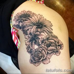 Фото татуировки букета цветов в технике black and grey на плече. Реалистичный рисунок татуировки с розами, подсолнухами и другими цветами.