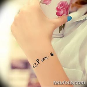 Фото тату надписи 'I am' на запястье, выполненной черными чернилами. Простой и лаконичный рисунок татуировки, символизирующий самоопределение и уверенность в себе.