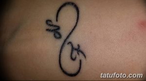 Фото тату: небольшая татуировка символа бесконечности с инициалами 'M' и 'K', выполненная тонкими черными линиями. Простой и элегантный рисунок татуировки.