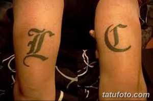 Фото тату: две готические буквы 'L' и 'C' на предплечьях, выполненные в черном цвете.