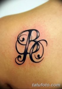 Фото татуировки на плече: изящная монограмма из букв 'R' и 'C', выполненная в черном цвете, витиеватый дизайн.