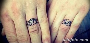 Фото парных татуировок на пальцах с инициалами 'KM' и изображением сердечка, выполненное тонкими черными линиями.