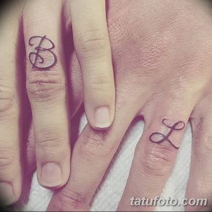 Фото парных тату инициалов 'B' и 'L' на пальцах рук. Черно-белые рисунки татуировок, выполненные в каллиграфическом стиле.