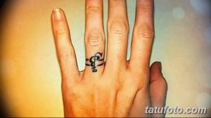 Фото тату с изображением слова 'Love' и сердца, выполненных на пальце руки. Татуировка выполнена в небольшом размере и в черном цвете.