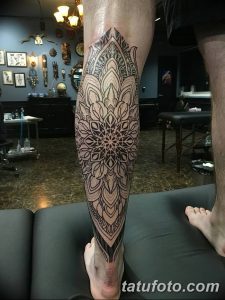 Фото тату на голени: большая мандала, выполненная в технике blackwork, с множеством мелких деталей и геометрических узоров. Эскиз татуировки в стиле ориентал.