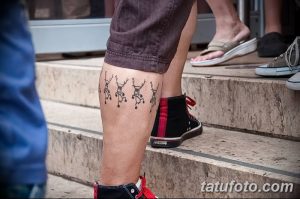 Фото тату: минималистичные черные татуировки в виде схематичных человечков, расположенные на голени. Простой дизайн, юмористический стиль.
