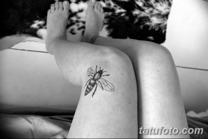 Фото татуировки пчелы на колене. Черно-белый рисунок, минималистичный стиль, детализированная проработка крыльев и тела пчелы.