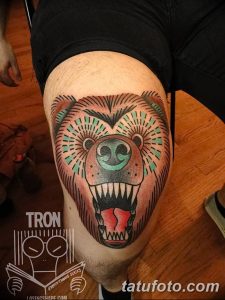 Фото тату на колене: голова медведя с открытой пастью и яркими деталями. Детализированный рисунок татуировки в стиле олдскул.