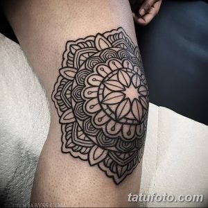 Фото тату мандалы на колене, выполненной в технике blackwork. Детализированный рисунок татуировки с геометрическими узорами и тонкими линиями.