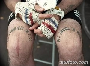 Фото тату: текстовая татуировка на коленях с надписью "Kilometres en plus" и "Des ennuis en moins". Черный цвет, простой шрифт.