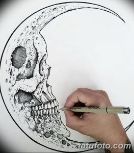 Фотография эскиза татуировки: череп, интегрированный в полумесяц, выполненный в технике графики и дотворк. Мрачный и детализированный рисунок.