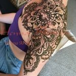 Фото мехенди, украшающего плечо и грудь девушки. Сложный узор из растительных мотивов и геометрических фигур выполнен в традиционном стиле.