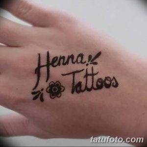 Фото тату хной на руке с надписью "Henna Tattoos" и небольшим цветочным орнаментом. Идеально для любителей каллиграфии и мехенди.