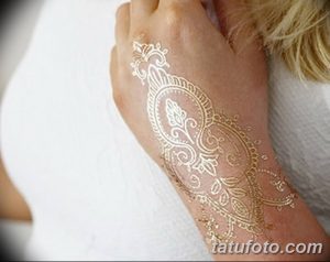 Фото татуировки хной на тыльной стороне руки. Детализированный узор в восточном стиле, выполненный золотой краской.